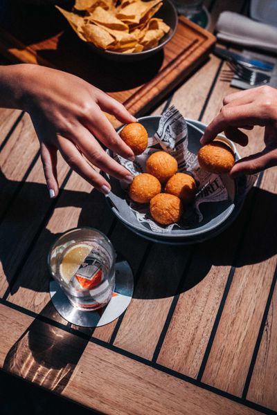 Freunde teilen Getränke und leckere Snacks bei After Five bei Omundo